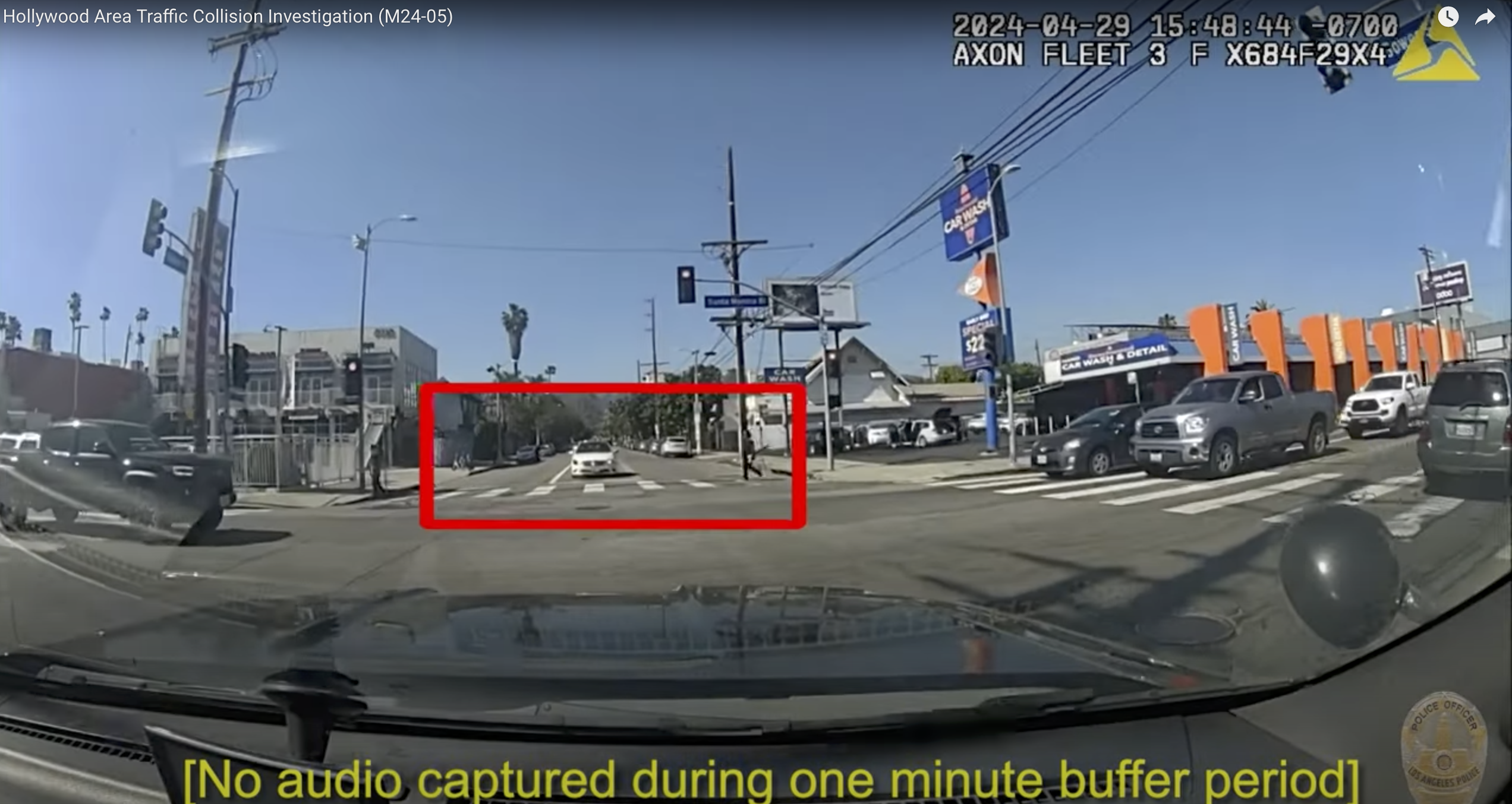 A screenshot from video footage released by the LAPD on May 29, 2024 shows an LAPD patrol SUV stopped at a red light, while a pedestrian walks through a clearly marked sidewalk.